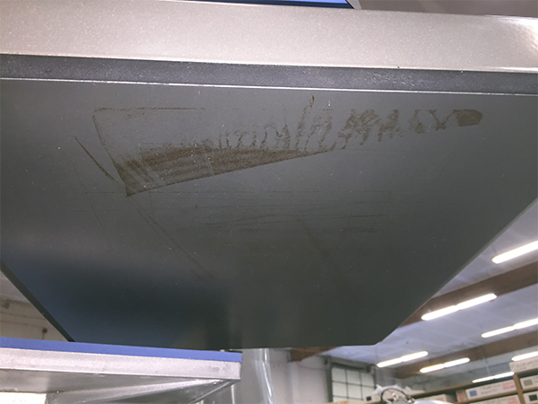 picture of a heat press upper platen with marks from previous transfers stuck to it
