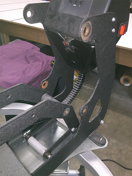 picture of a disassembled heat press showing the rusted, worn out joints