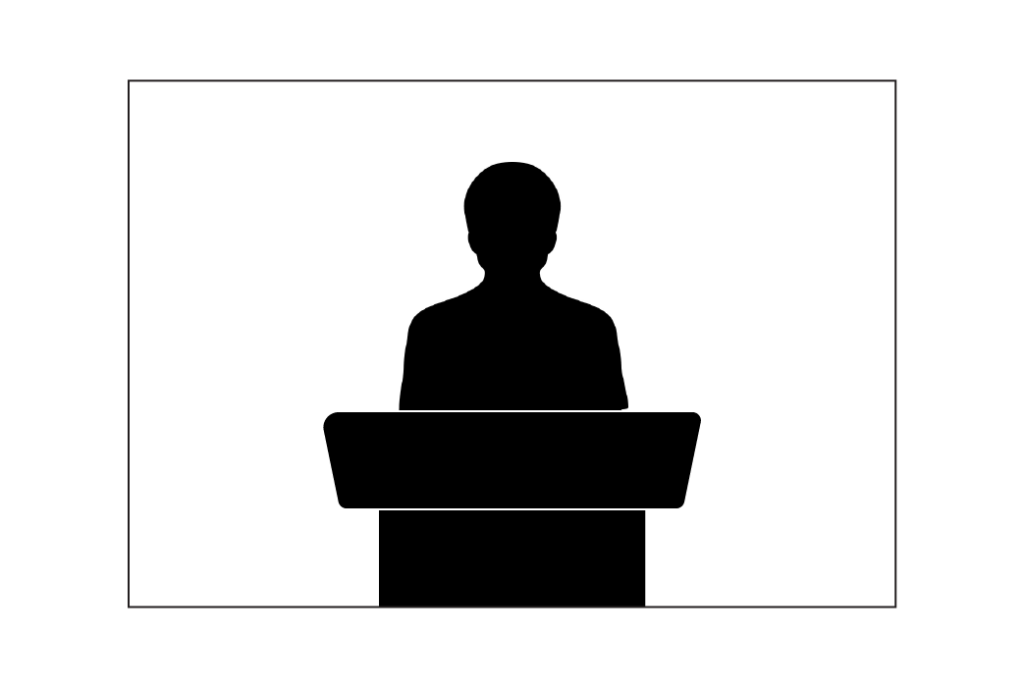 silhouette of a person standing at a speaker stand